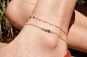Model layering multiple silver anklets. One silver anklet with 3mm moonstone and purple amethyst. 