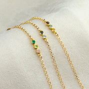 Trio of gold anklets. One gold anklet with 3 stones including garnet, aqua chalcedony and citrine. One gold anklet with topaz and kyanite. One gold anklet with green onyx, peridot and pink chalcedony