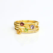 Stacking dainty ring set in gold plated with citrine, peridot, purple amethyst and garnet birthstones. November gemstone on white back ground. 