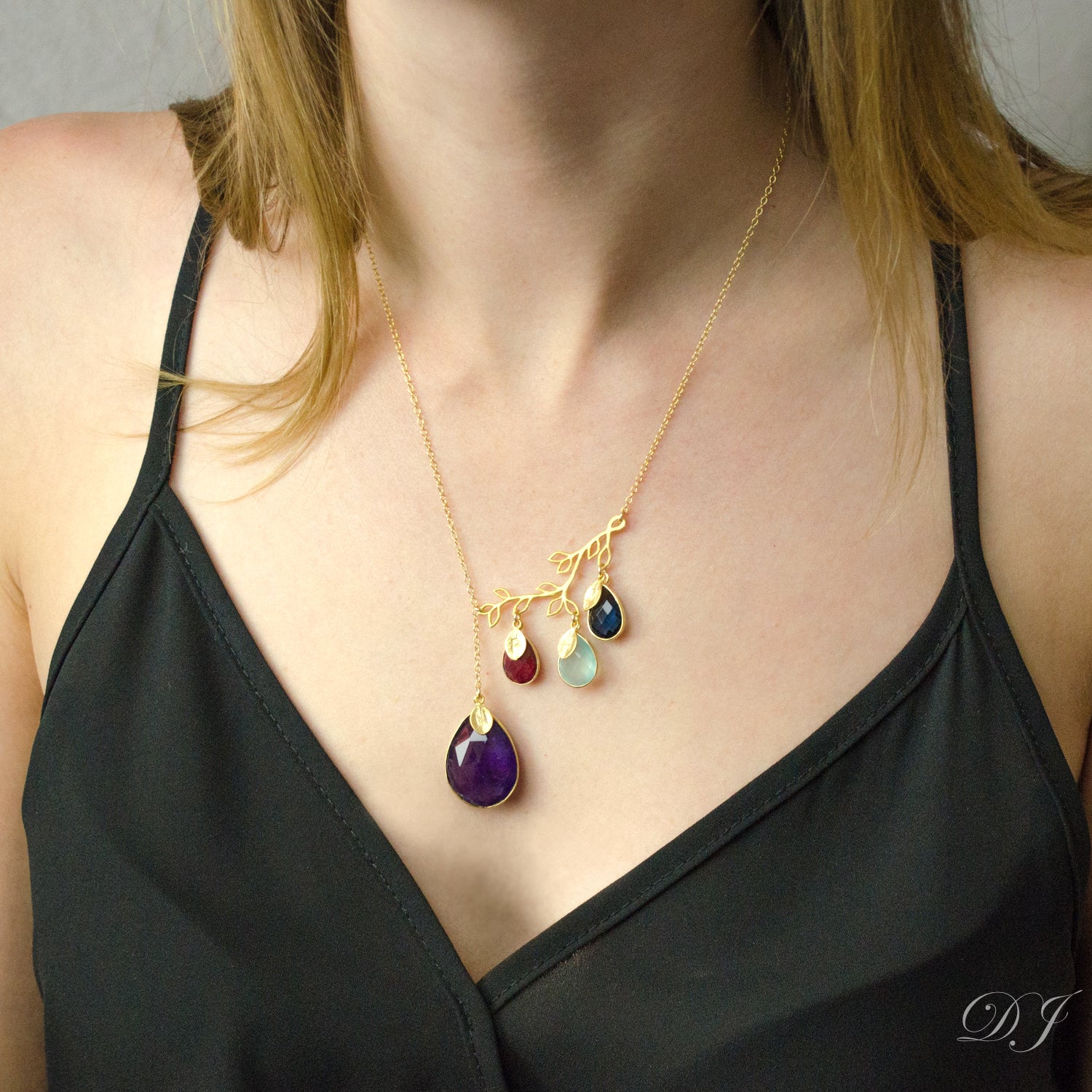 Model is wearing our gold filled family tree branch necklace with kysanite, garnet, blue topaz and kyanite and stamped leaf charms. 