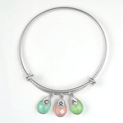 Single silver teardrop birthstone bangle with hand stamped leaf charms has aqua chalcedony, pink chalcedony and green chalcedony birthstones.