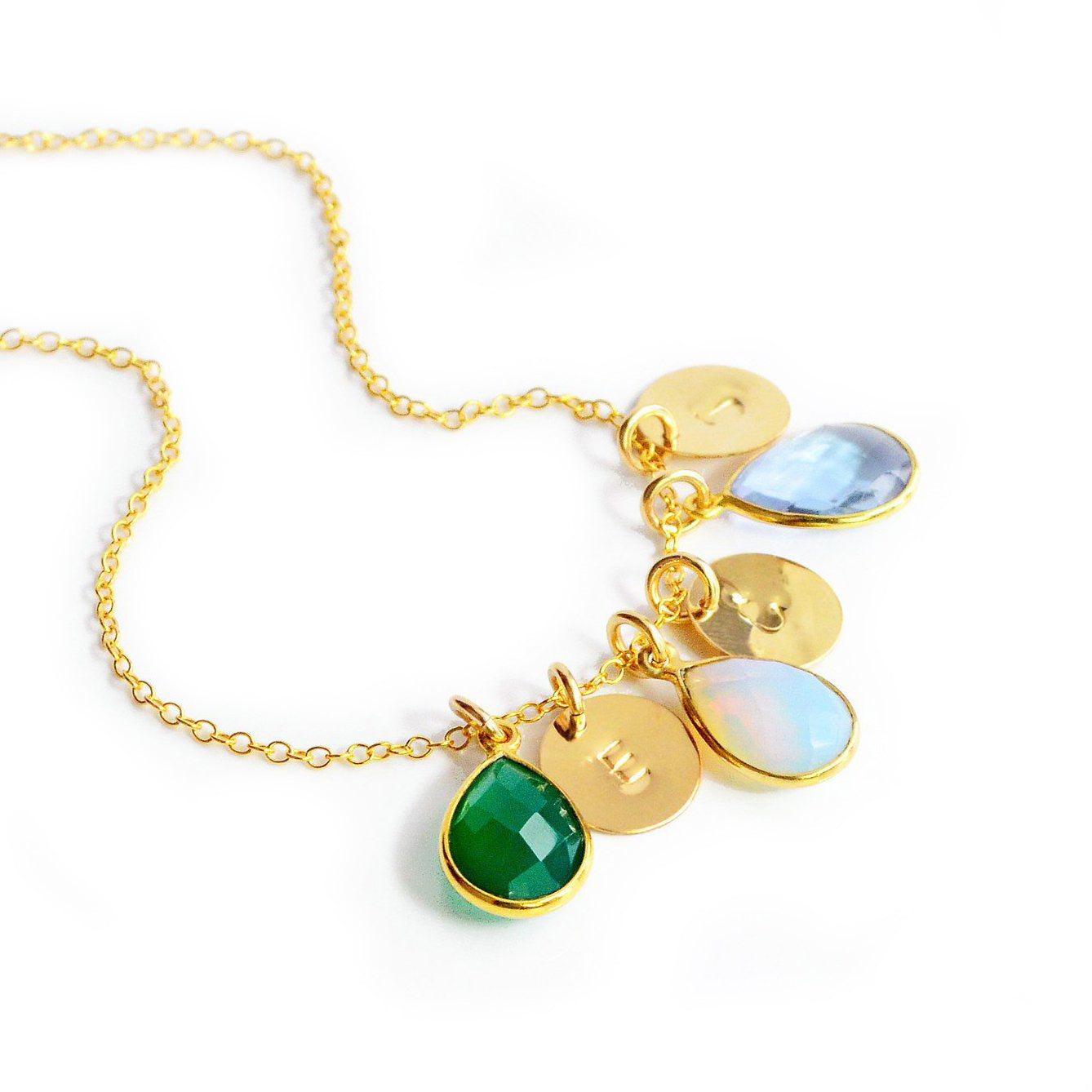 Gold filled cable teardrop and initial necklace with green onyx, moonstone and sky blue topaz birthstones on a white background with hand stamped initial letter disks. 