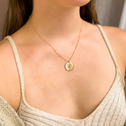Model in cream top is wearing a gold filled satellite chain with a custom engraved dog necklace 