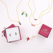 An overhead shot of a variety of adira gemstone bar pieces. Birthstone bar jewelry, modern gemstone bar jewelry. minimalist birthstone jewelry, necklace length as shown on model with white top. most popular length is 18 inches. jewelry gift, necklace gift for her, anniversary gift, christmas gift, valentine's day gift, wedding jewelry, bridesmaid's jewelry, gift for mom, gift for wife, gift for girlfriend, gift for grandma, mother's day gift