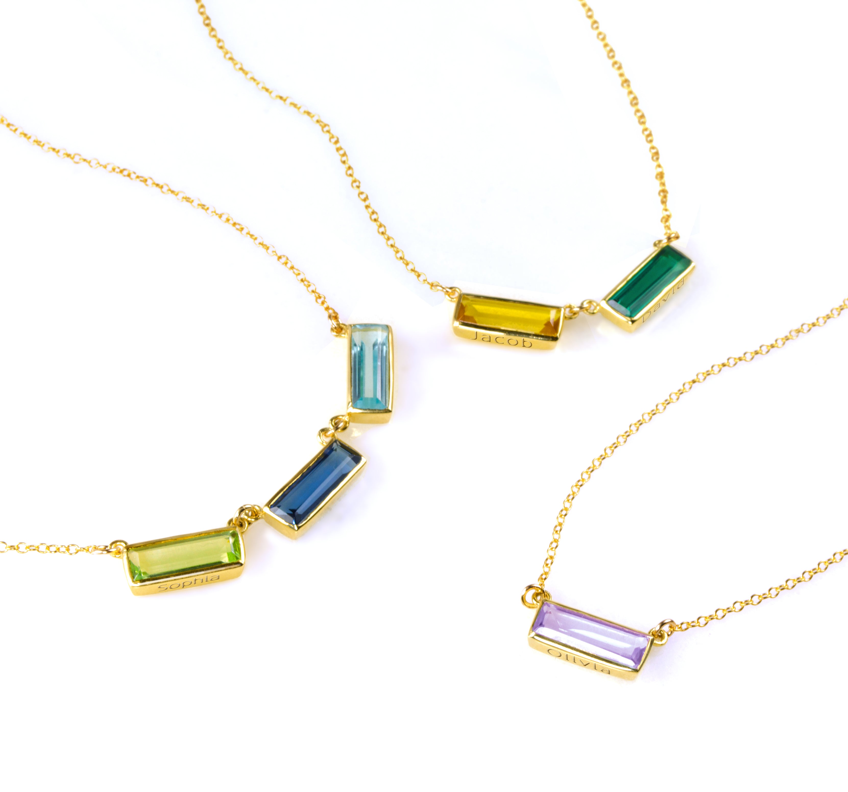 Collection of three adira horizontal bar necklaces with engraved secret message. One gold filled necklace with peridot, kyanite, and blue topaz. One gold gilled necklace with citrine and green onyx birthstones and 1 gold filled necklace with purple amethyst.