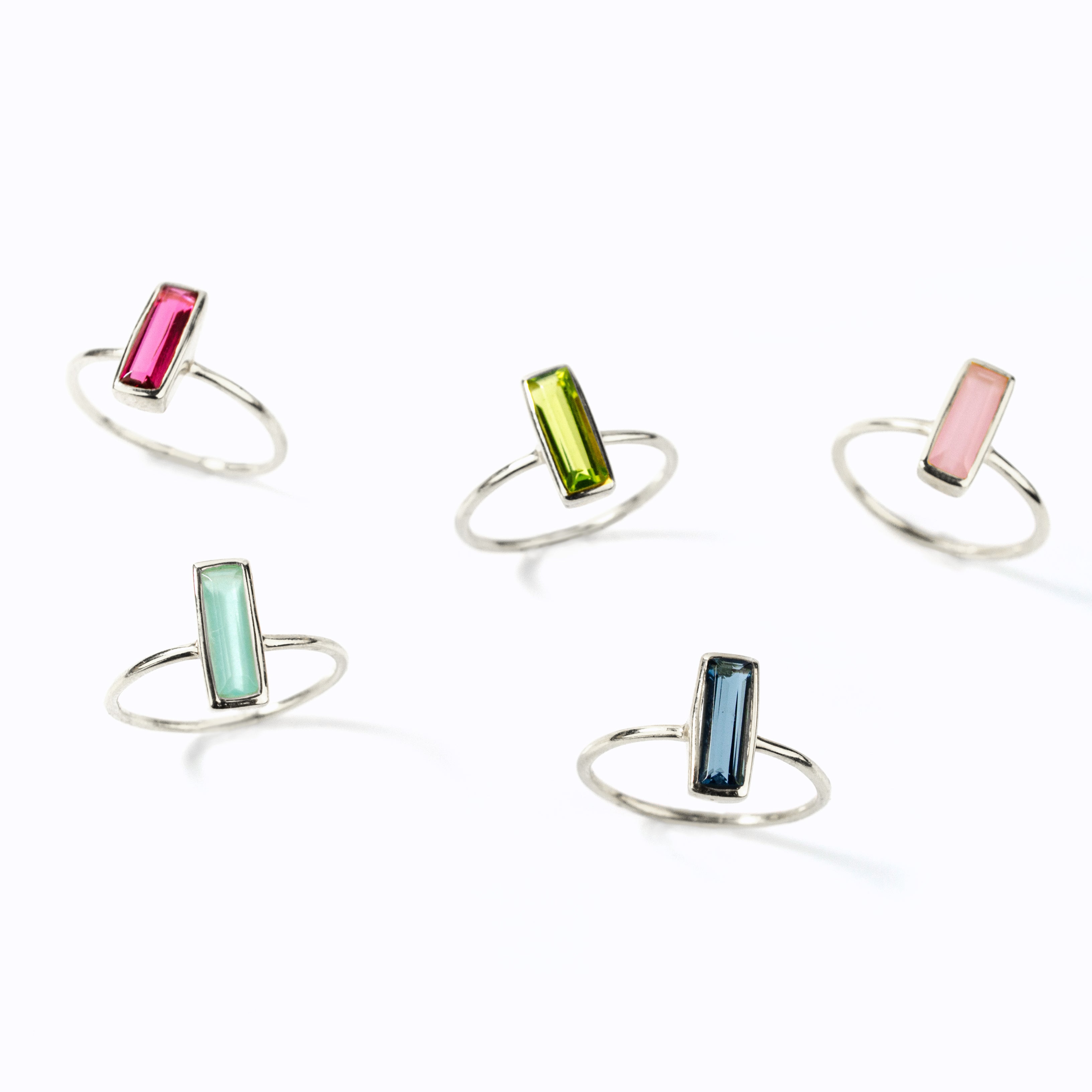 Shop the tiny adira bar ring collection! Sterling silver rings shown in ruby, peridot pink chalcedony, aqua chalcedony and kyanite birthstones. 