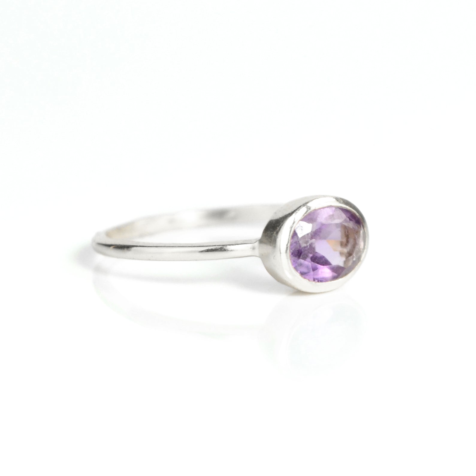 a sterling silver purple amethyst ring shown on white background. stackable! Stacking rings, bezel set, small oval, tiny oval, dainty oval, birthstone rings, sterling silver stamp, birthstone ring, birthstone jewelry, purple gemstone, purple birthstone, february birthstone, february gemstone, purple gemstone, purple birthstone, february birthstone, february gemstone, stack set, stacking rings, gemstone ring, birthstone ring, mother's day gift for her, gift for mom, gift for fiance, gift for girlfriend