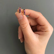Hand holding tiny baguette birthstone stud earrings