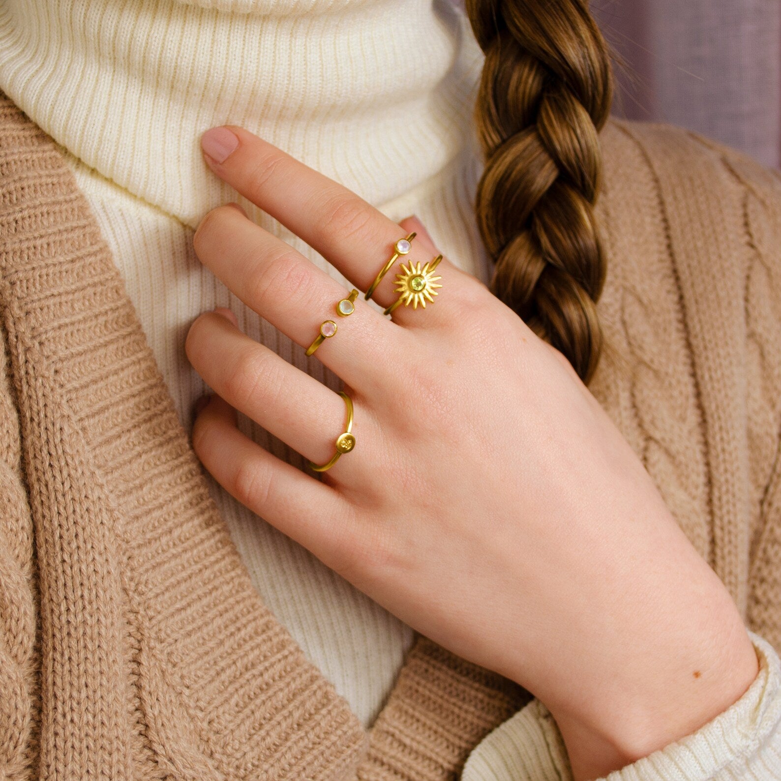 Mix and match these dainty 3mm birthstone bezel rings! Model is stylishly stacking peridot sun burst with moonstone on pointer finger. Middle finger has open adjustable dainty ring and ring finger has single gold plated citrine gemstone. 
