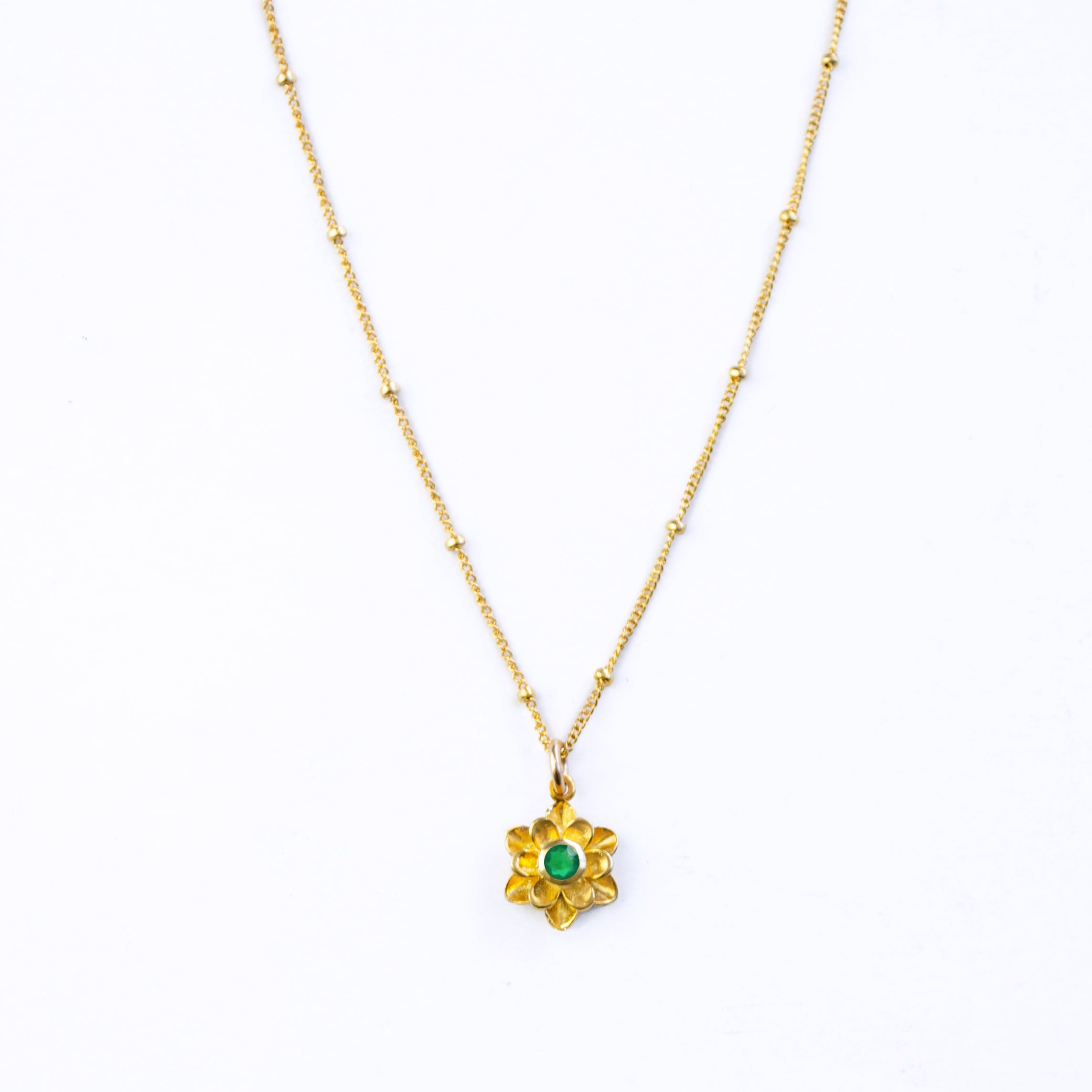 Large gold filled floral flower bloom necklace with satellite chain and green onyx birthstone on a white background. 