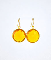 Large gold filled hook round citrine gemstone earrings. November birthstone on white background