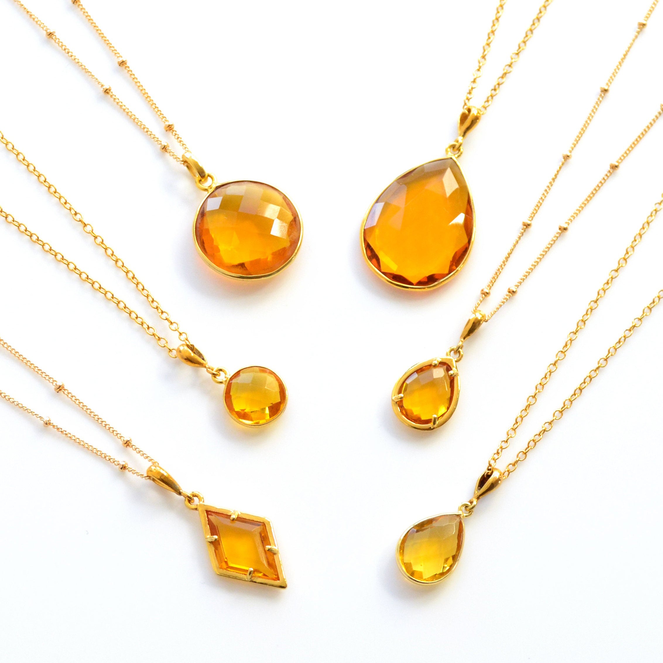 Shop our citrine necklace collection available in large, medium and small teardrops, prong set teardrop, prong set diamond, large and medium rounds on white background. Choose from satellite or cable chain. November birthstone. 