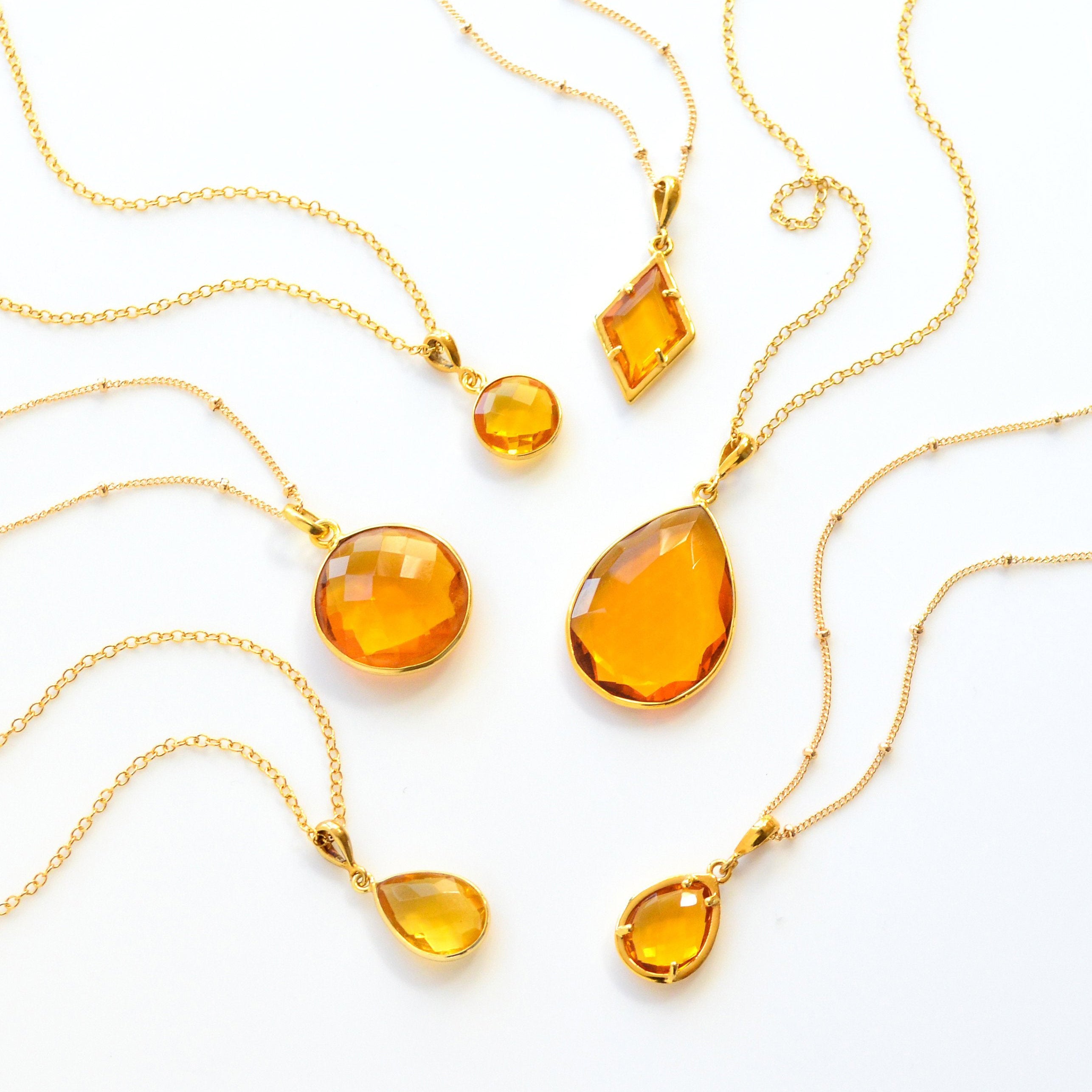 Shop our citrine necklace collection available in large, medium and small teardrops, prong set teardrop, prong set diamond, large and medium rounds on white background. Choose from satellite or cable chain. November birthstone. White background