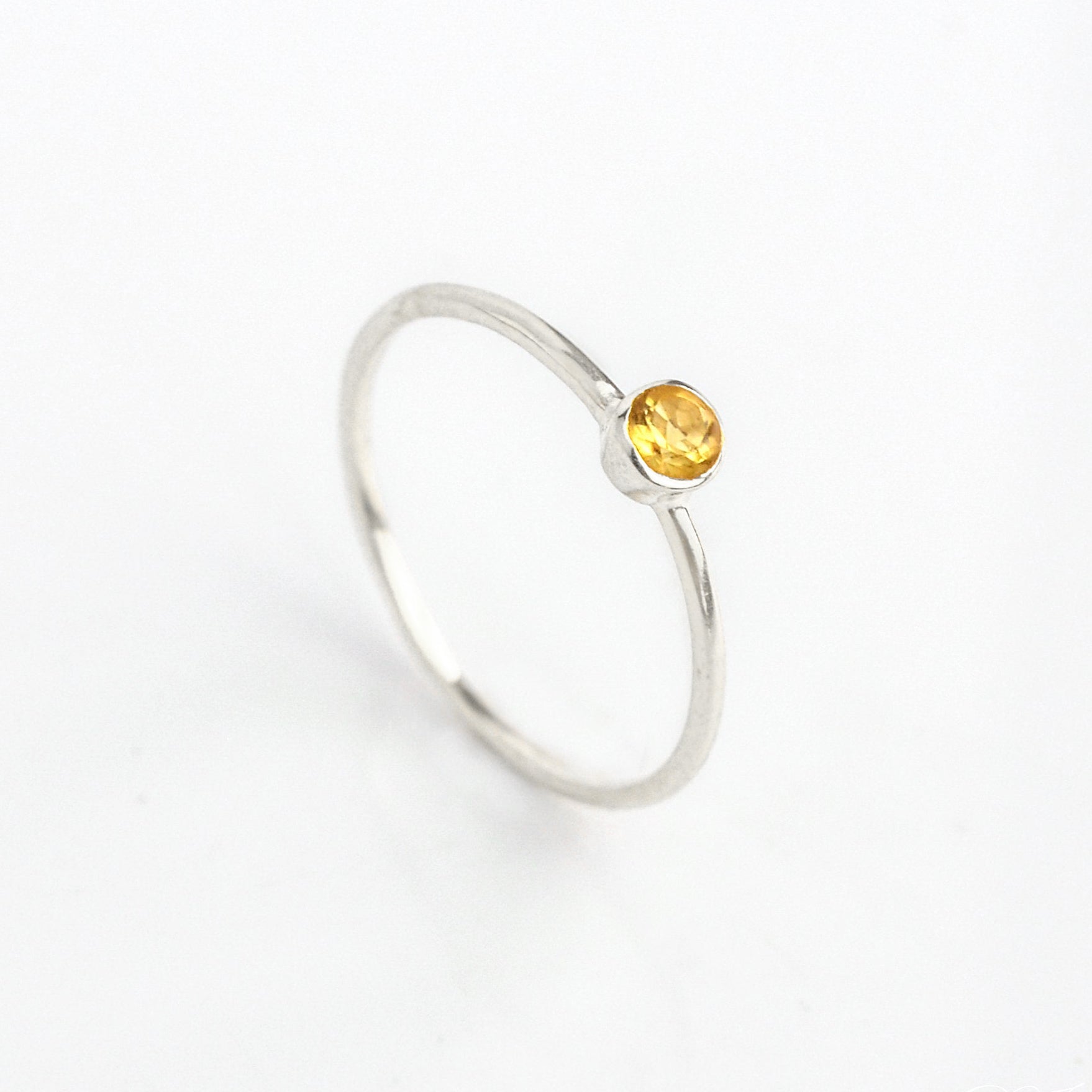 Sterling silver dainty 3mm citrine gemstone ring. November birthstone. On white background. 