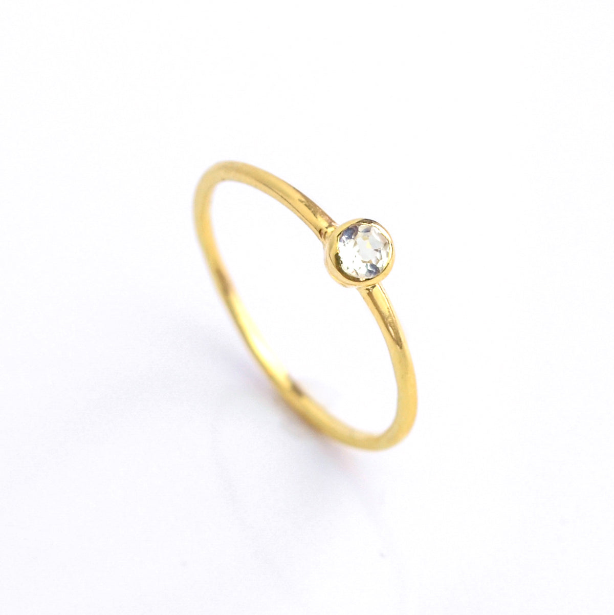 Single gold plated dainty 3mm clear quartz gemstone ring. april  birthstone. On white background. 925 sterling silver, birthstone ring, stacking ring, stackable, birthstone jewelry, facet gemstone