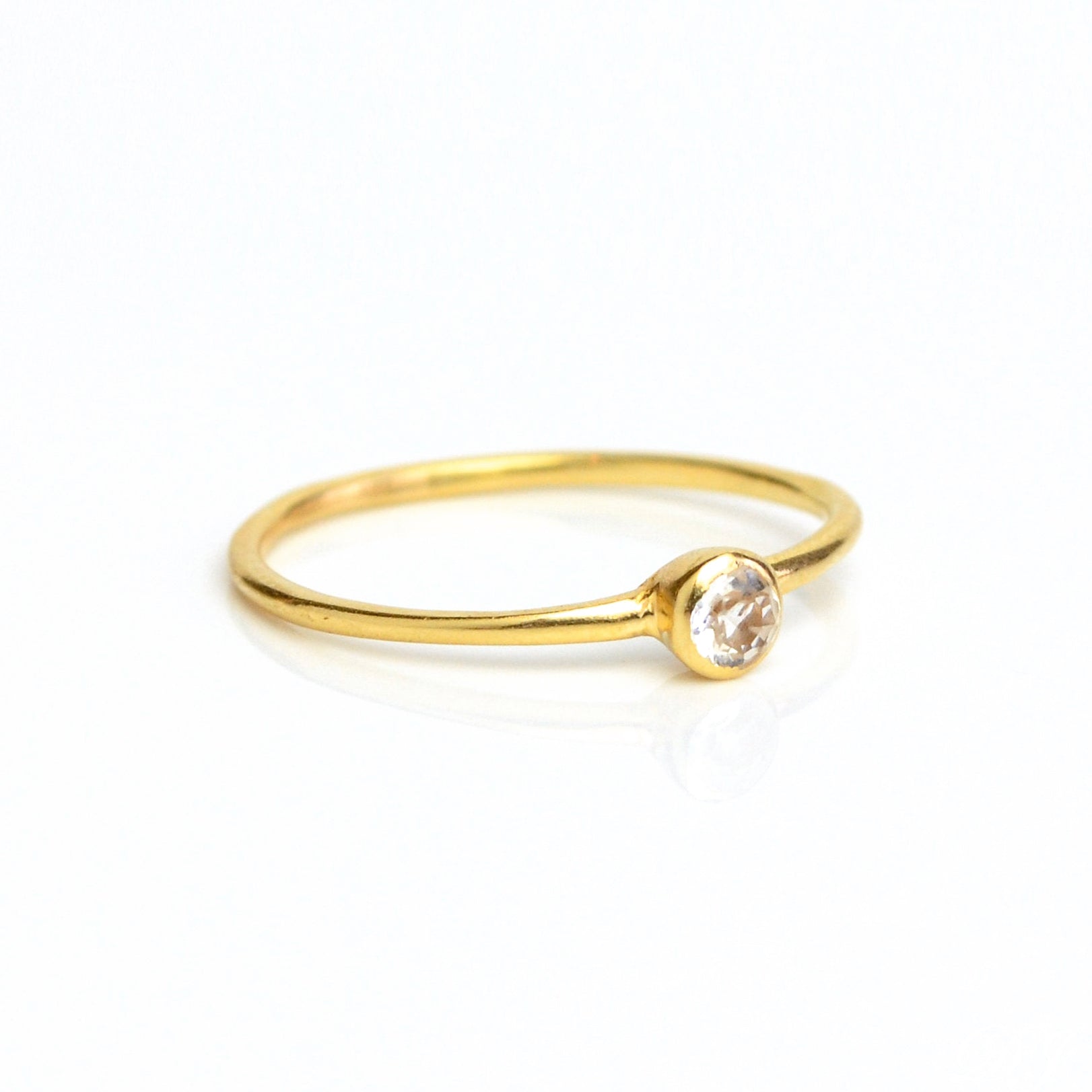 Single gold plated dainty 3mm clear quartz gemstone ring. april  birthstone. On white background. 925 sterling silver, birthstone ring, stacking ring, stackable, birthstone jewelry, facet gemstone