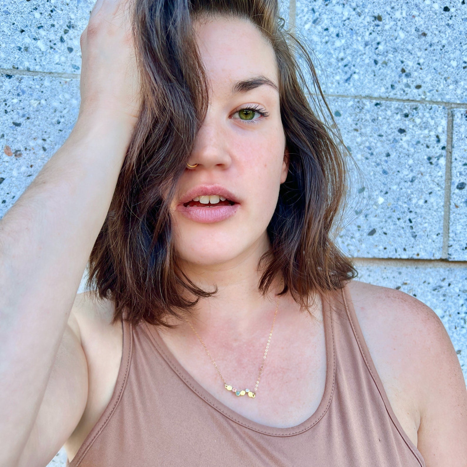 Young woman wearing dainty birthstone and initial necklace