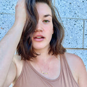 Young woman wearing dainty birthstone and initial necklace