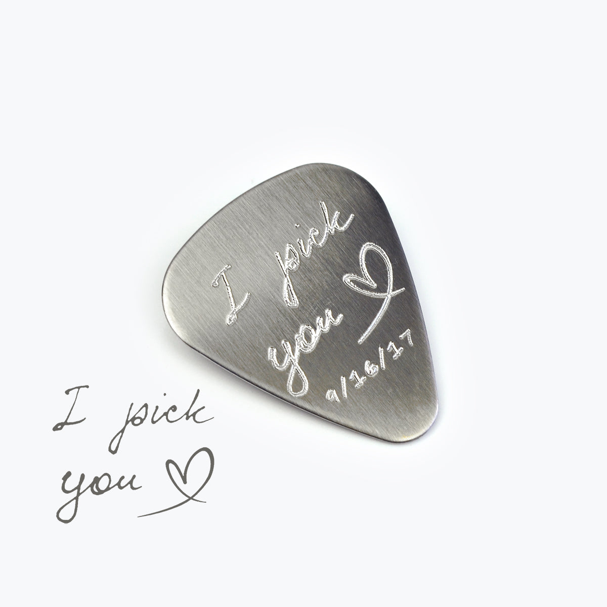 Single guitar pick with I pick you design, heart and date engraved on white background.