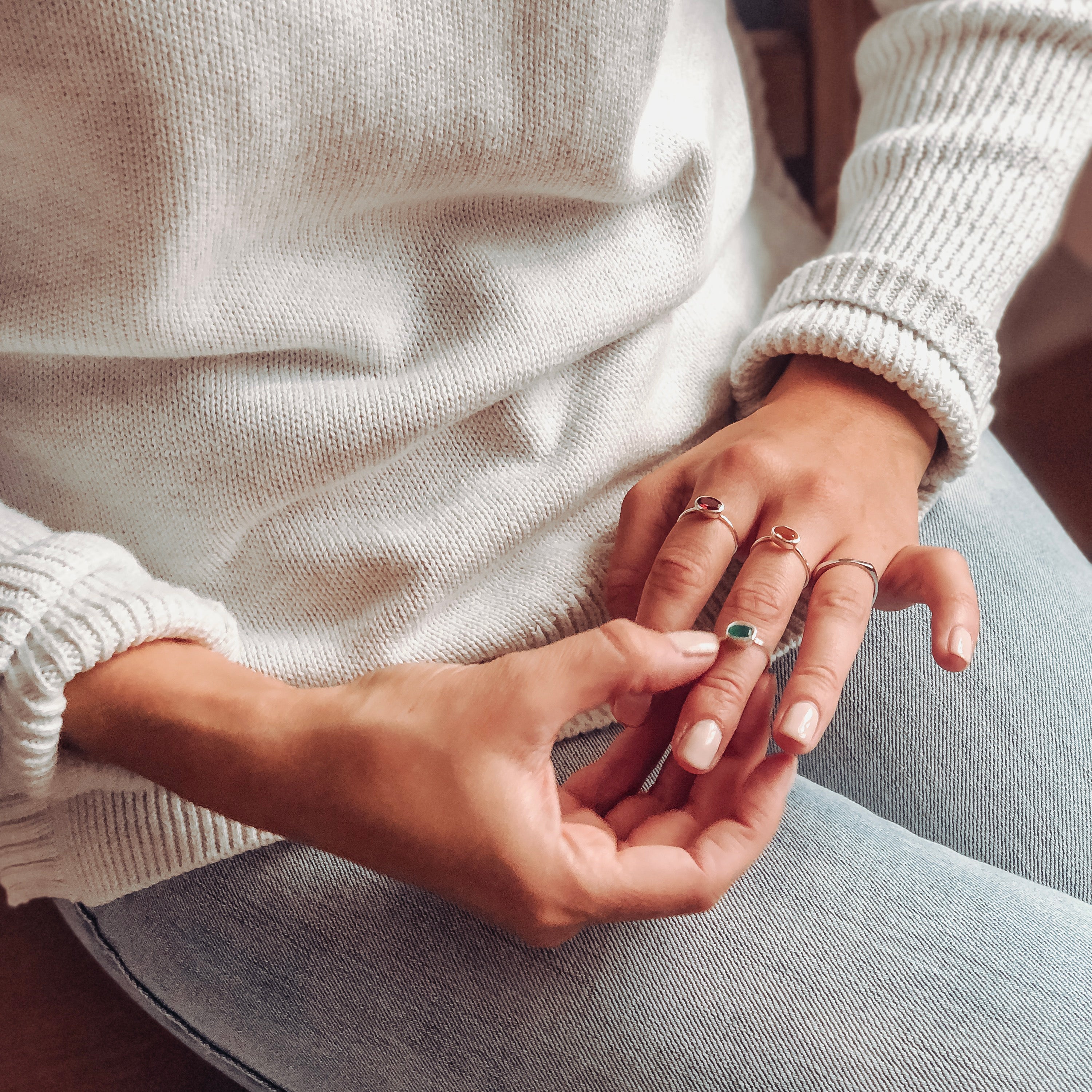 Elegant oval stackable birthstone rings styled casually with amethyst for February and aquamarine for March. Personalized family jewelry for moms, daughters, or everyday wear.