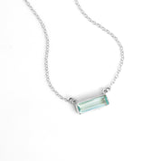 Single sterling silver cable chain with horizontal blue topaz december birthstone adira bar necklace on white background