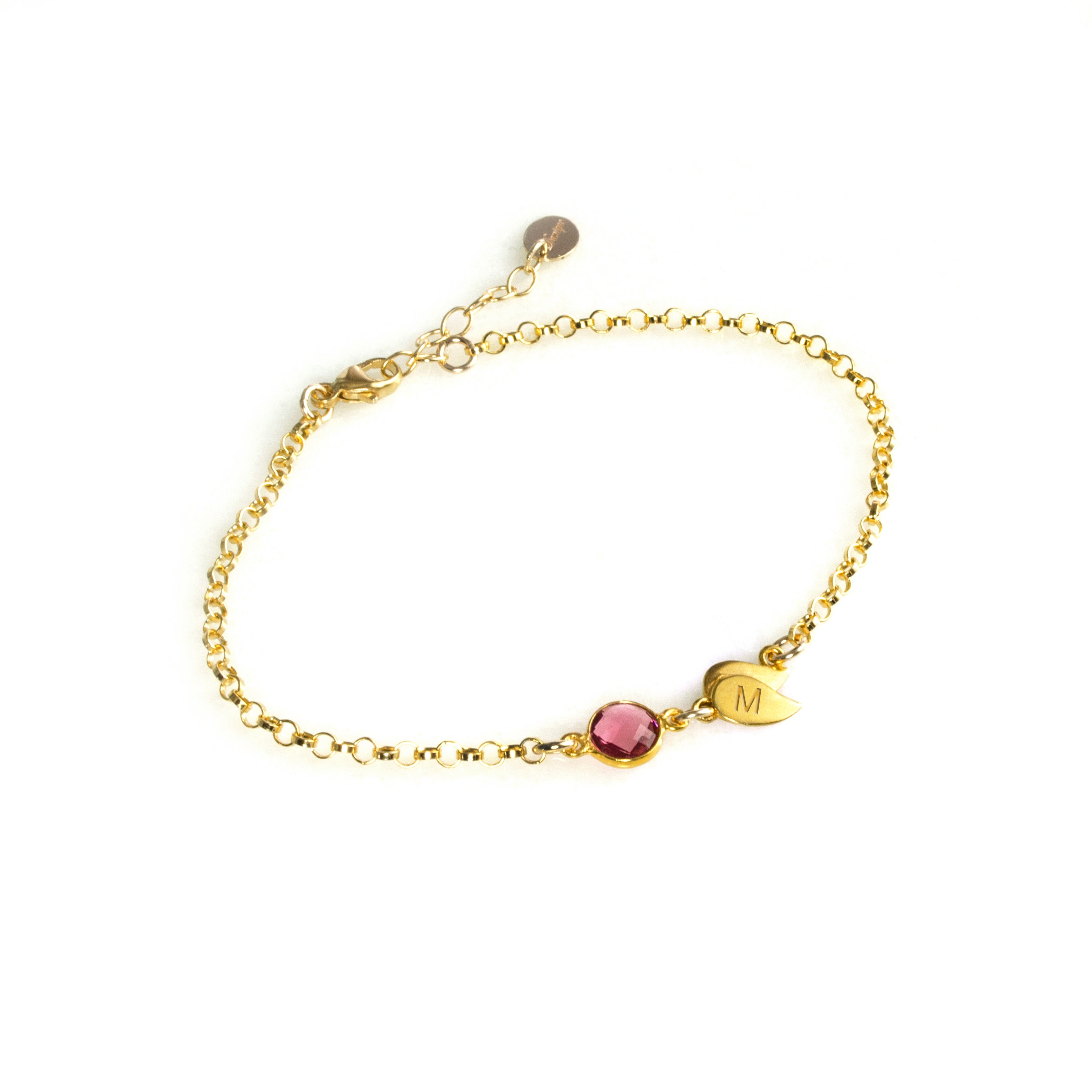 Gold filled double leaf charm with initial engraved and ruby birthstone on a white background. Ruby gemstone charm name