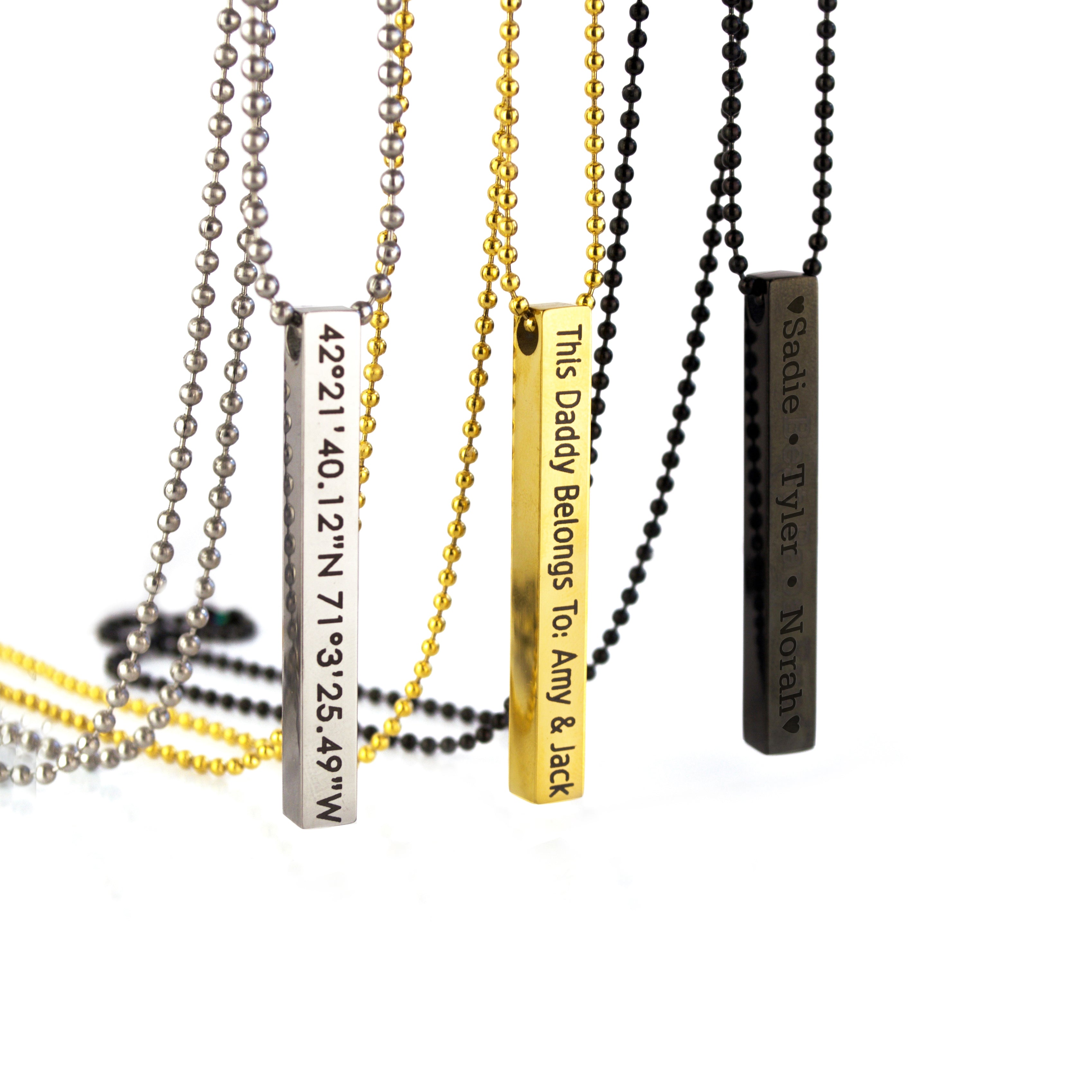 Three 3d Bar necklaces in silver with coordinates in block font, gold with a custom phrase in modern thin font, or black with names engraved in typewriter font.