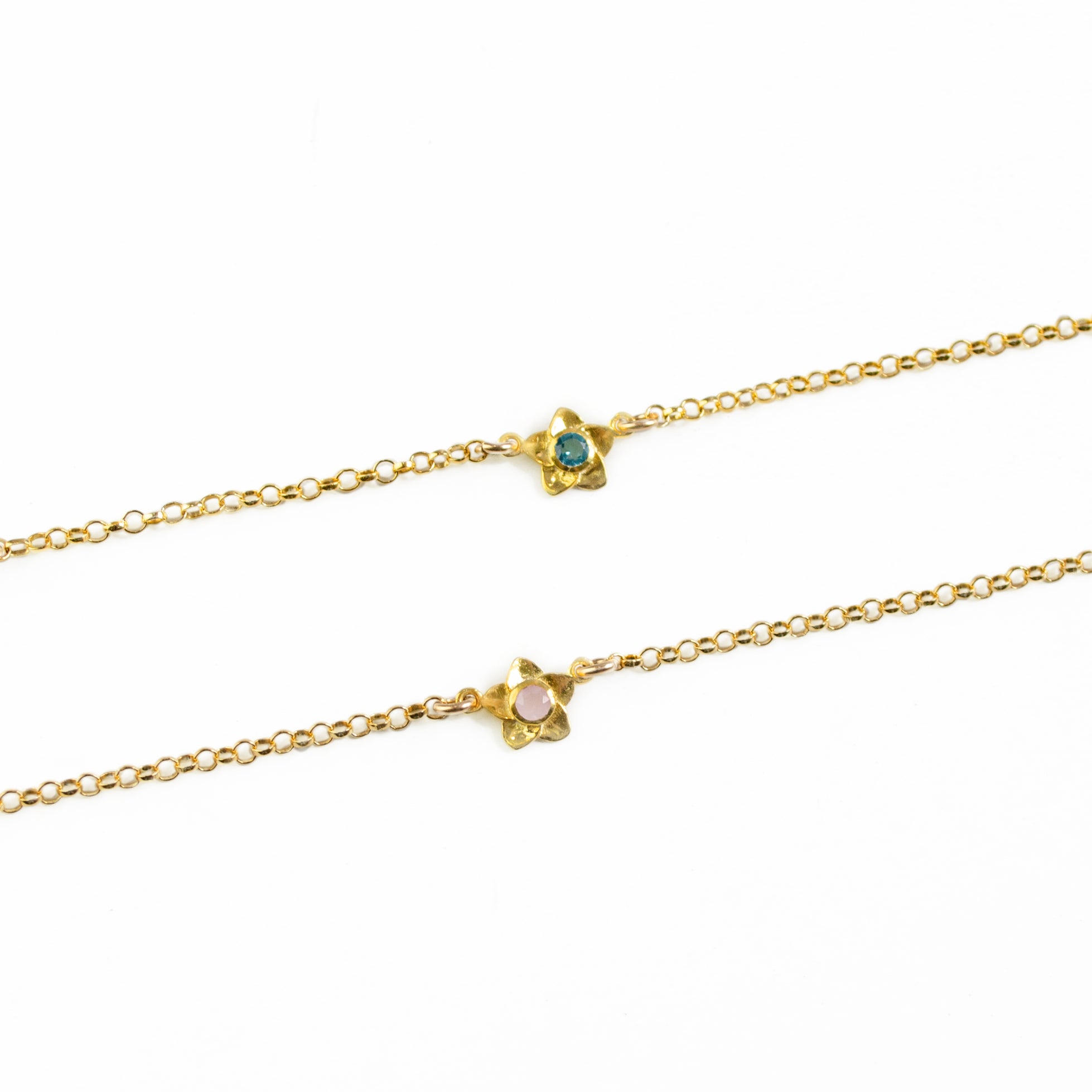 Two gold filled bloom bracelets featuring one birthstone each. Top birthstone is kyanite and bottom is pink chalcedony. 