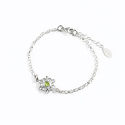 Sterling silver bloom bracelet with single mother flower with peridot birthstone on white background. 
