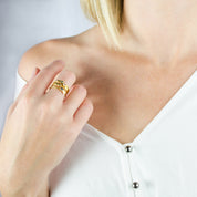 Model wearing a collection of stacking leaf birthstone rings with engraved initial on the front of ring leaf. 