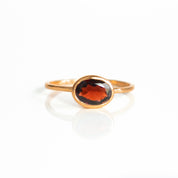 a rose gold garnet ring shown on white background. stackable! Stacking rings, bezel set, small oval, tiny oval, dainty oval, birthstone rings, sterling silver stamp, birthstone ring, birthstone jewelry, red gemstone, red birthstone, january birthstone, january gemstone, stack set, stacking rings, gemstone ring, birthstone ring, mother's day gift for her, gift for mom, gift for fiance, gift for girlfriend, wedding jewelry, bridesmaid jewelry, anniversary jewelry, anniversary gift, birthday gift, christmas 