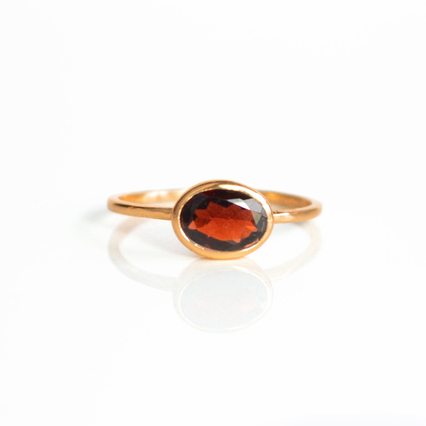 a rose gold garnet ring shown on white background. stackable! Stacking rings, bezel set, small oval, tiny oval, dainty oval, birthstone rings, sterling silver stamp, birthstone ring, birthstone jewelry, red gemstone, red birthstone, january birthstone, january gemstone, stack set, stacking rings, gemstone ring, birthstone ring, mother's day gift for her, gift for mom, gift for fiance, gift for girlfriend, wedding jewelry, bridesmaid jewelry, anniversary jewelry, anniversary gift, birthday gift, christmas 