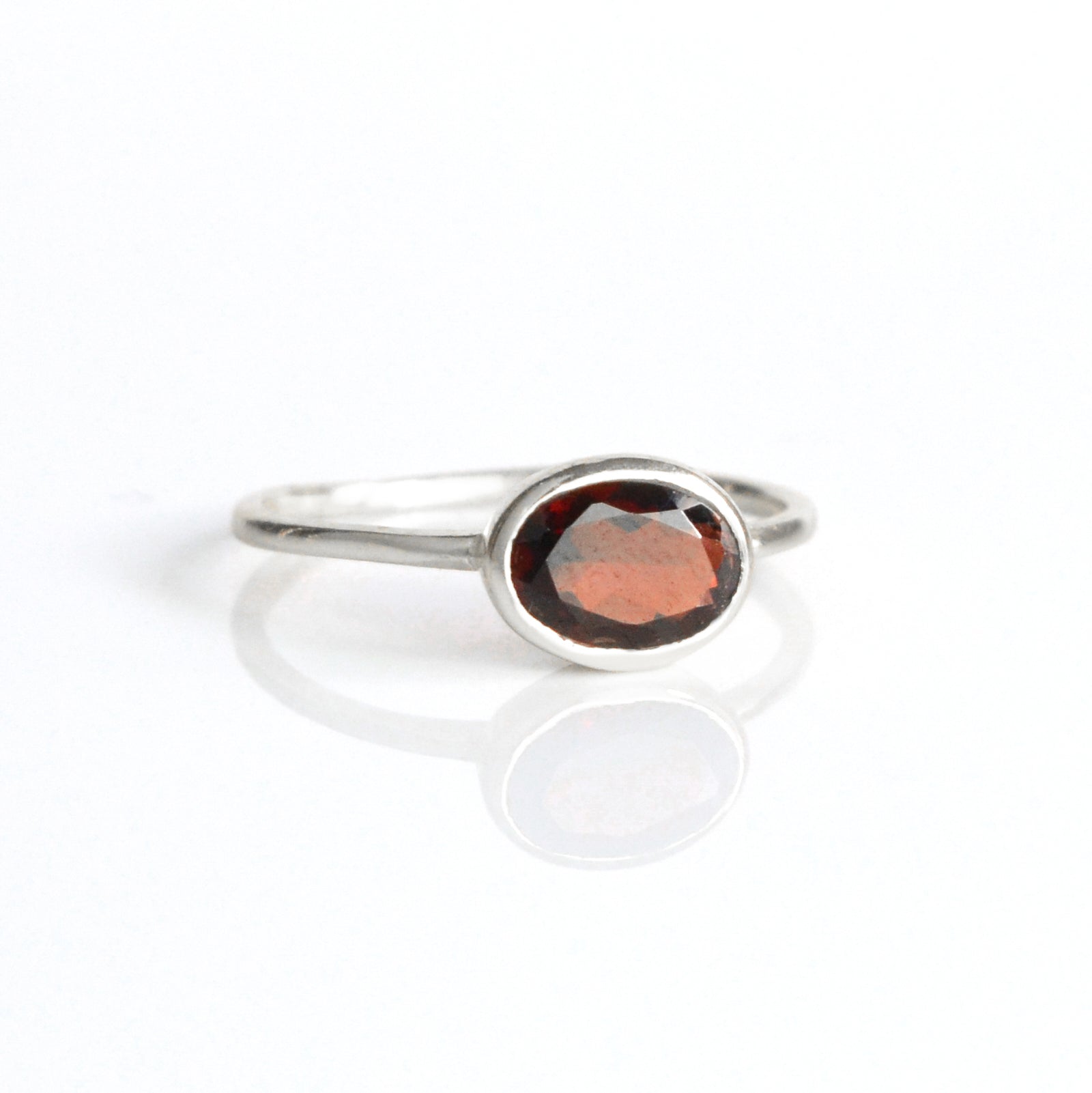 a sterling silver garnet ring shown on white background. stackable! stack set, stacking rings, gemstone ring, birthstone ring, mother's day gift for her, gift for mom, gift for fiance, gift for girlfriend, wedding jewelry, bridesmaid jewelry, anniversary jewelry, anniversary gift, birthday gift, christmas gift, valentine's day gift, valentine's day rings, dainty ring, cocktail ring, statement ring, bezel set, birthstone jewelry, birthstone ring