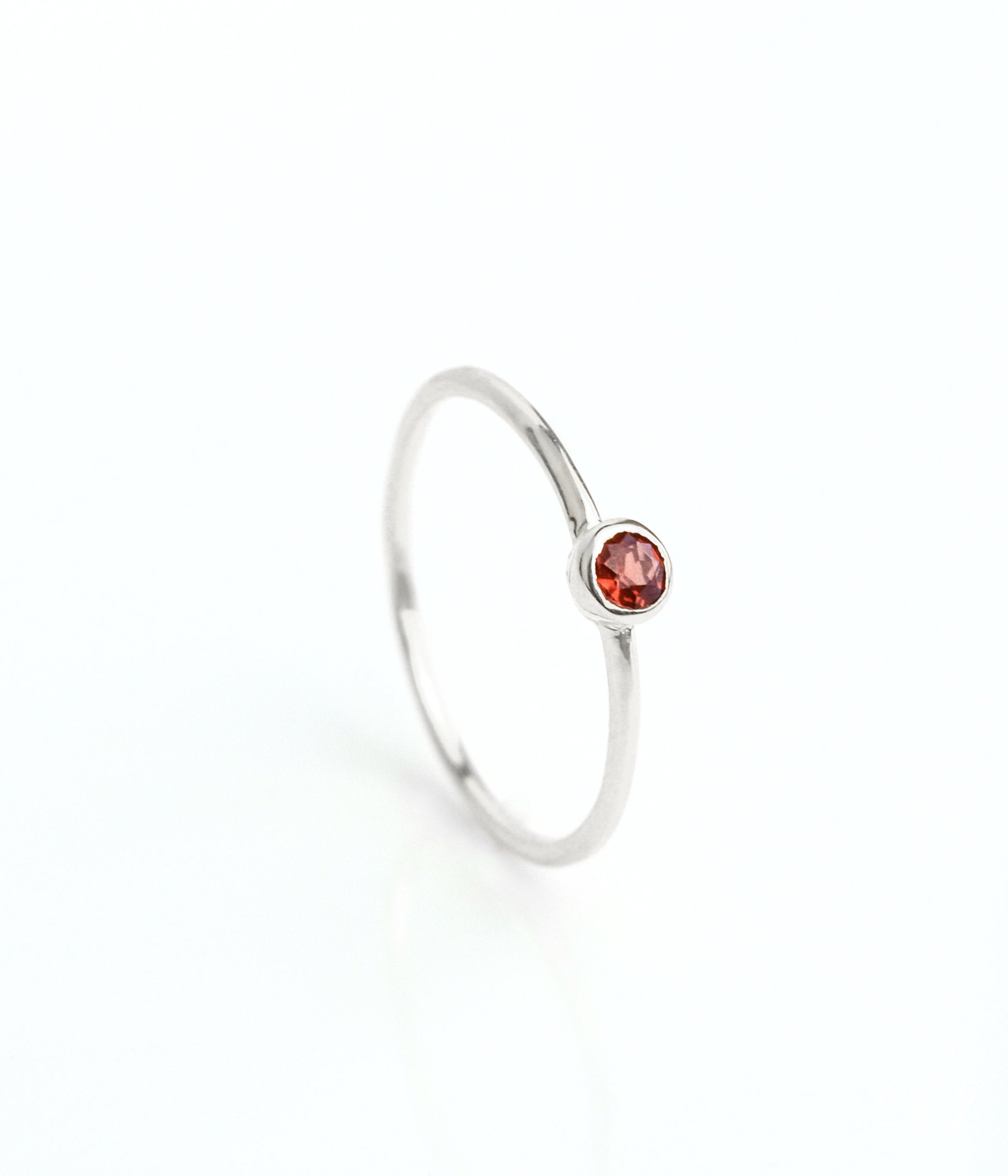 sterling silver dainty 3mm garnet gemstone ring. January birthstone. On white background. 925 sterling silver, birthstone ring, stacking ring, stackable, birthstone jewelry, facet gemstone