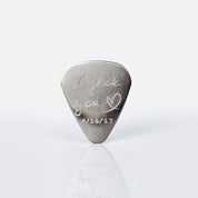 Single guitar pick with I pick you design, heart and date engraved on white background.