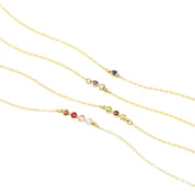 This necklace can hold 1, 2, 3, or 4 birthstones on this bar setting. Necklace with single Iolite birthstone. Middle necklace with two birthstones including purple amethyst and blue topaz. Middle necklace featuring 3 stones are peridot, garnet and citrine. Last necklace has four birthstones including garnet, ruby, pink chalcedony and blue topaz