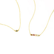 Two dainty birthstone bar necklaces show. One gold with single kyanite stone. Second necklace has 4 birthstones including ruby, garnet, pink chalcedony and green amethyst.