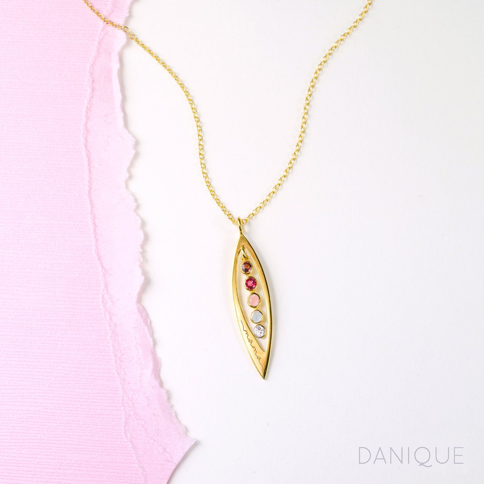 Gold filled mothers family tree necklace with open leaf pendant featuring garnet, ruby, pink chalcedony, aqua chalcedony and clear birthstones with mama engraving on white background