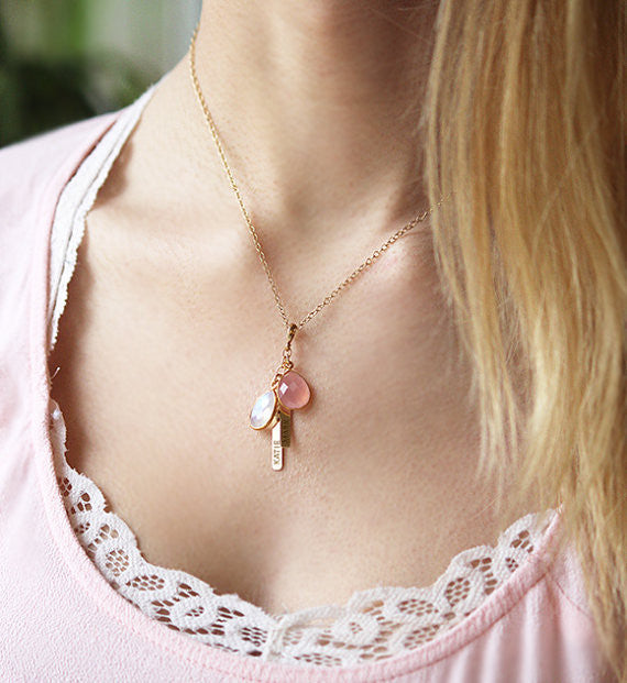 Model wearing gold filled cable style necklace with pink chalcedony and moonstone with tiny bar engraved with names.