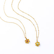 Two large blossom floral bloom necklaces first with cable chain and ruby birthstone and second with satellite chain and aqua chalcedony birthstone. 