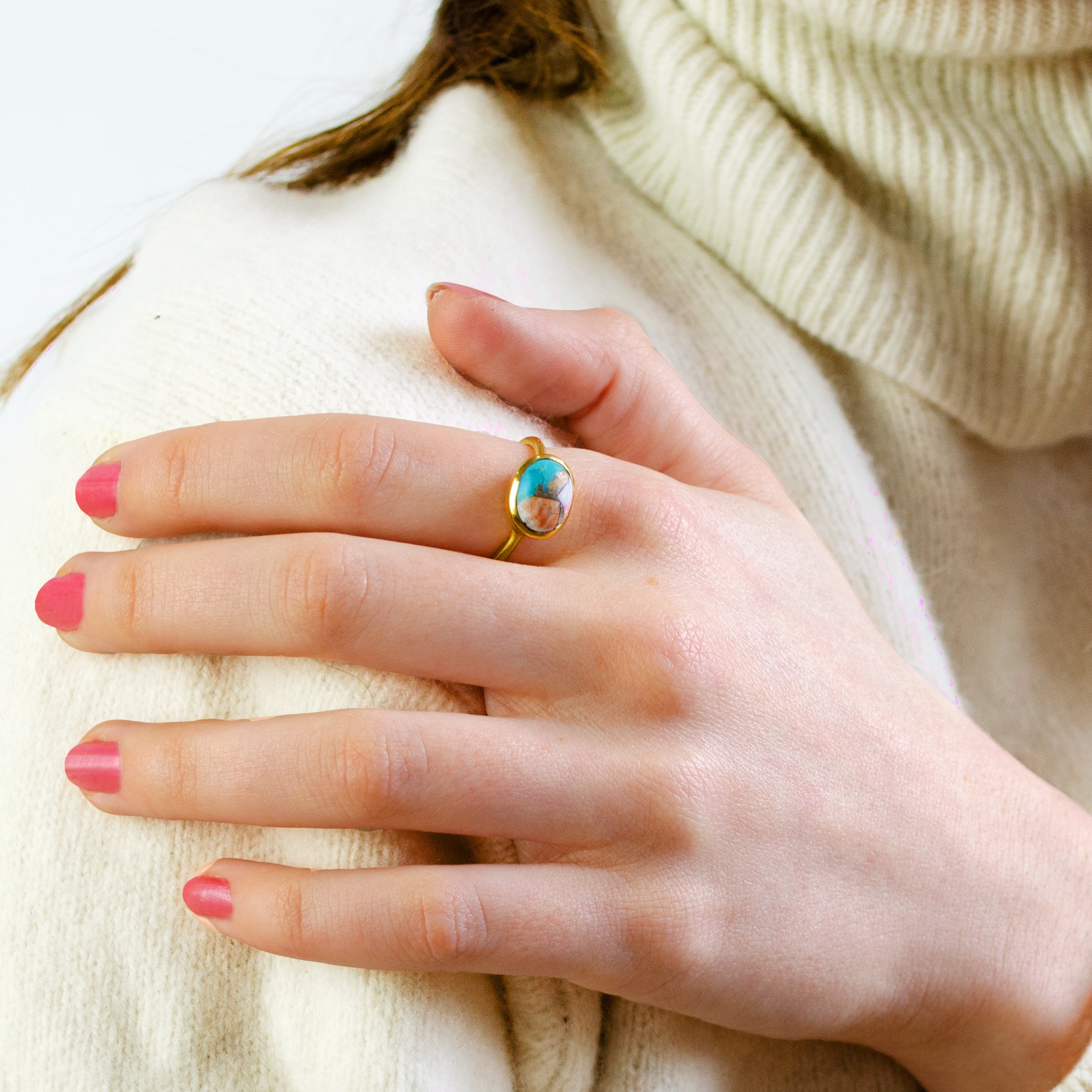Model in white sweater is wearing sterling silver Oval mohave copper turquoise ring, december birthstone ring, blue purple gemstone, Bezel set, Sterling silver or gold, faceted ring, december gift