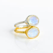Side-by-side comparison of rainbow moonstone oval rings in rose gold vermeil and yellow gold vermeil. Faceted bezel-set gemstone with blue flash; slim stacking band for minimalist style. Choose your finish and ring size 5–10 to create a delicate everyday set or a romantic promise ring. Ideal June birthstone gift for her, handcrafted with attention to detail.
