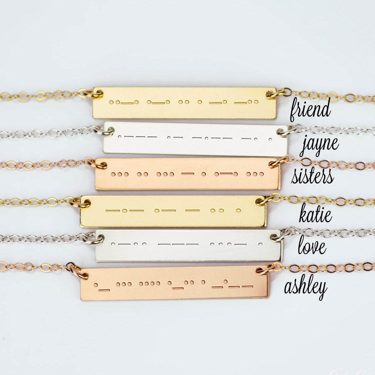 Layered Morse code bar necklaces in gold, sterling silver and rose gold filled, each skinny horizontal plate engraved with secret dot and dash messages like “friend,” “sisters,” “love,” custom name jewelry, personalized gift for best friend, sister, bridesmaid.