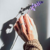 Model is wearing a sterling silver mother and child ring with peridot as the large 5mm stone and kyanite and aqua chalcedony birthstones. 