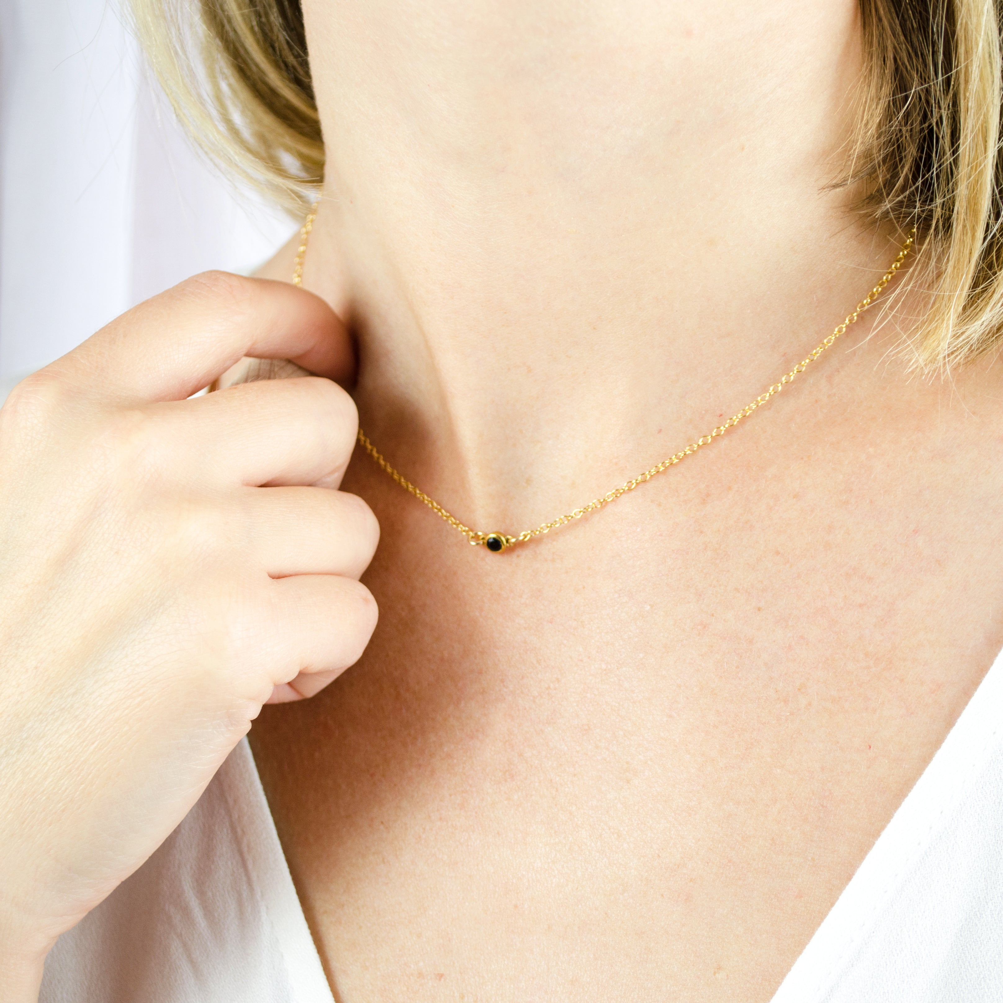 Model is wearing the dainty 3mm bar necklace in gold with black onyx