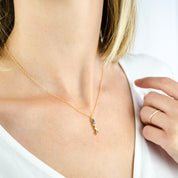 Model is wearing a gold filled 4 birthstone vertical bar necklace with blue topaz, aqua chalcedony, clear and citrine birthstones