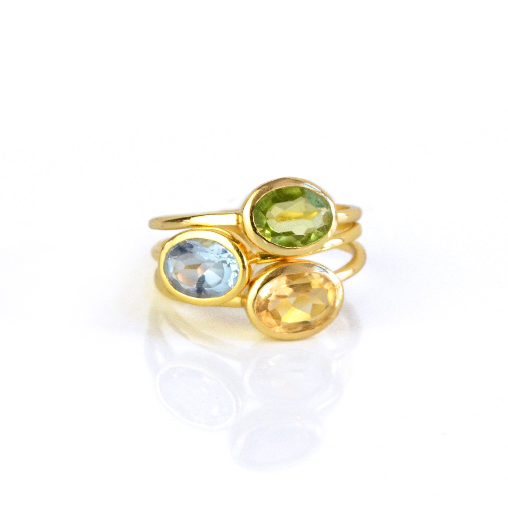 Stackable oval birthstone rings in sterling silver and vermeil gold with aquamarine for March, peridot for August, and citrine for November. Personalized stacking gemstone rings for moms, daughters, or women’s everyday jewelry, available in all 12 birthstones.