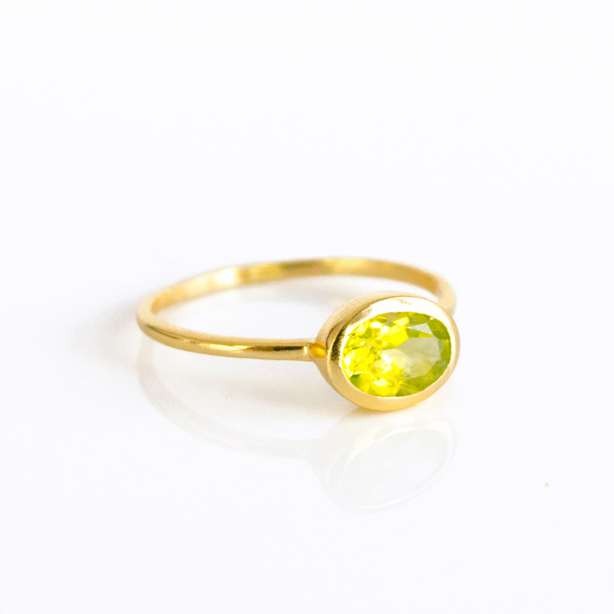 a gold peridot ring shown on white background. birthstone jewelry, august birthstone, august birthday, green ring, peridot birthstone. stack set, stacking rings, gemstone ring, birthstone ring, mother's day gift for her, gift for mom, gift for fiance, gift for girlfriend, wedding jewelry, bridesmaid jewelry, anniversary jewelry, anniversary gift, birthday gift, christmas gift, valentine's day gift, valentine's day rings, dainty ring, cocktail ring, statement ring, bezel 