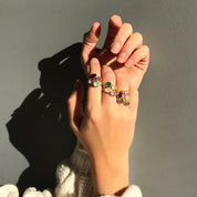 Custom oval gemstone rings glowing in sunlight, featuring aquamarine for March, garnet for January, and citrine for November. Stackable birthstone jewelry for moms, daughters, or best friends.
