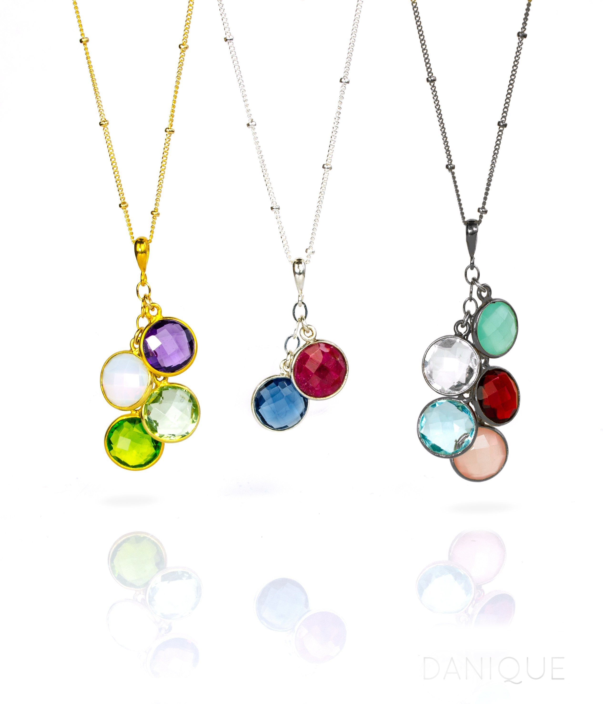 Three satellite chain necklaces. First in gold with purple amethyst, moonstone, green amethyst and peridot birthstones. Middle necklace features garnet and kyanite stones in sterling silver. Last necklace is oxidized silver with aqua chalcedony, clear, garnet, sky blue quartz and pink chalcedony birthstones